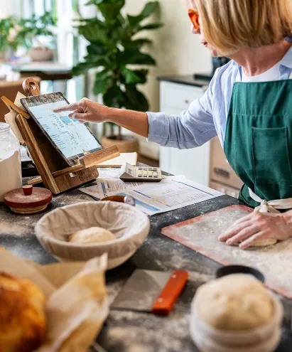 Woman in her kitchen cooking and looking up recipes