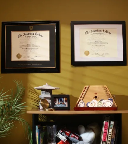 Photo of two diplomas on an office wall