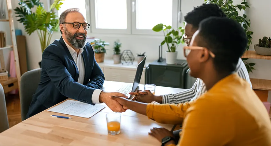 Married couple shaking hands with advisor