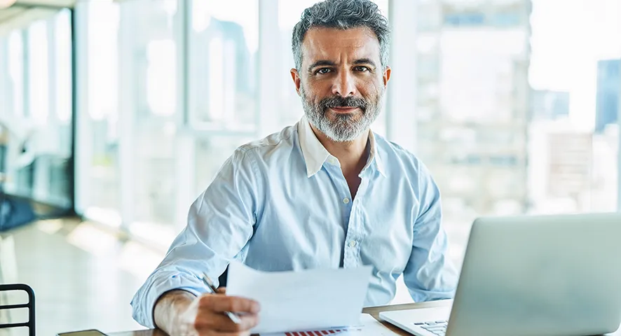 Middle aged man smiling while working at his desk