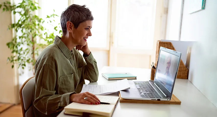 Elderly woman sitting at her desk on the computer