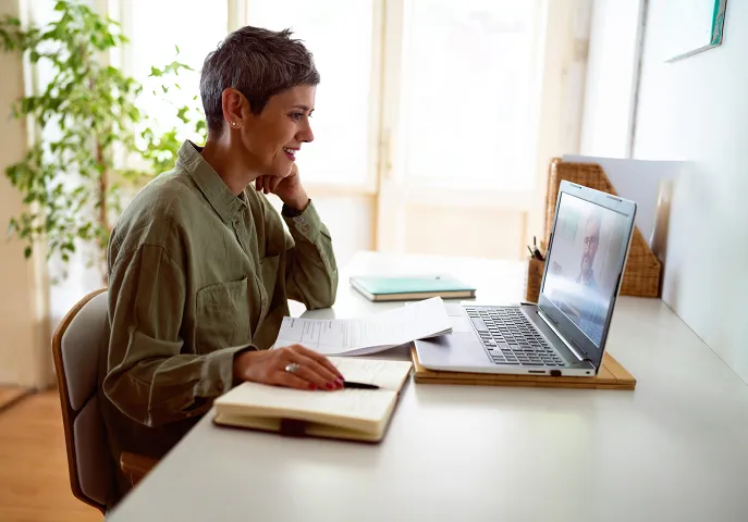 Elderly woman sitting at her desk on the computer
